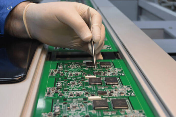 Man wearing glove working on circuit board