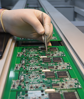 Man wearing glove working on circuit board