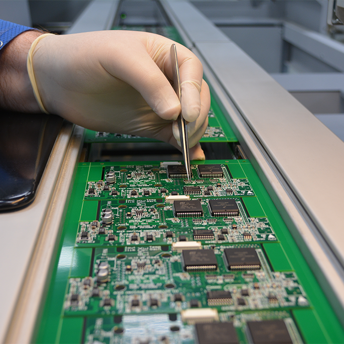 Man wearing glove working on circuit board